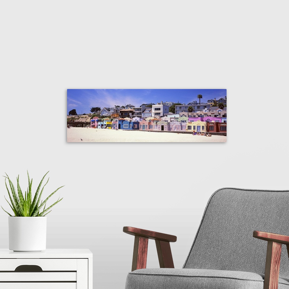 A modern room featuring Colorful buildings along a sandy boardwalk overlooking the water.