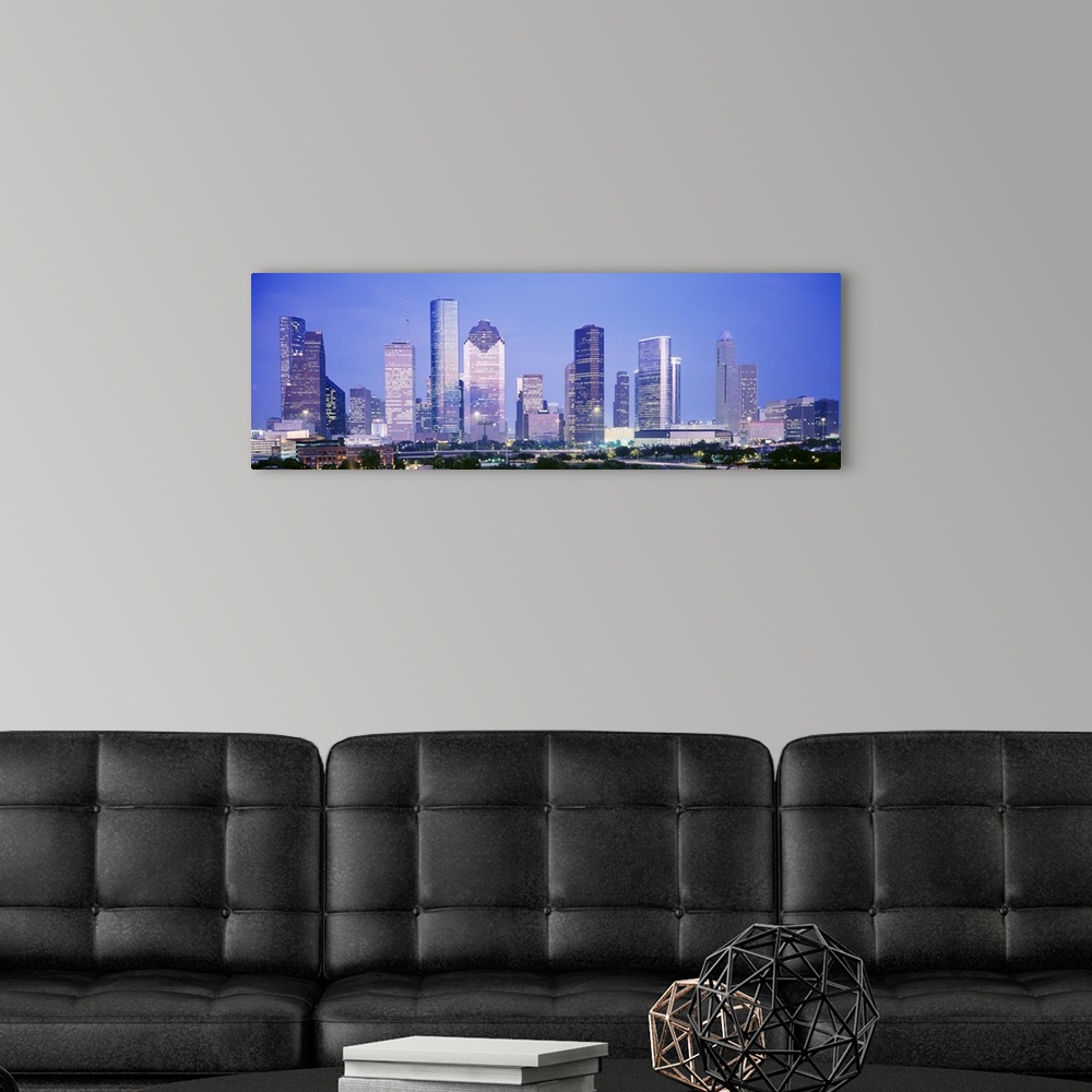 A modern room featuring Panoramic photograph of skyline lit up at dusk.