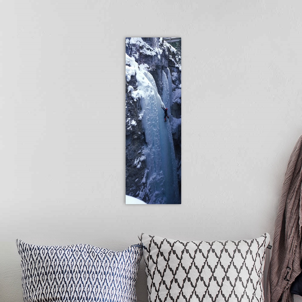 A bohemian room featuring Vertical panoramic photograph of climber on ice covered rock.