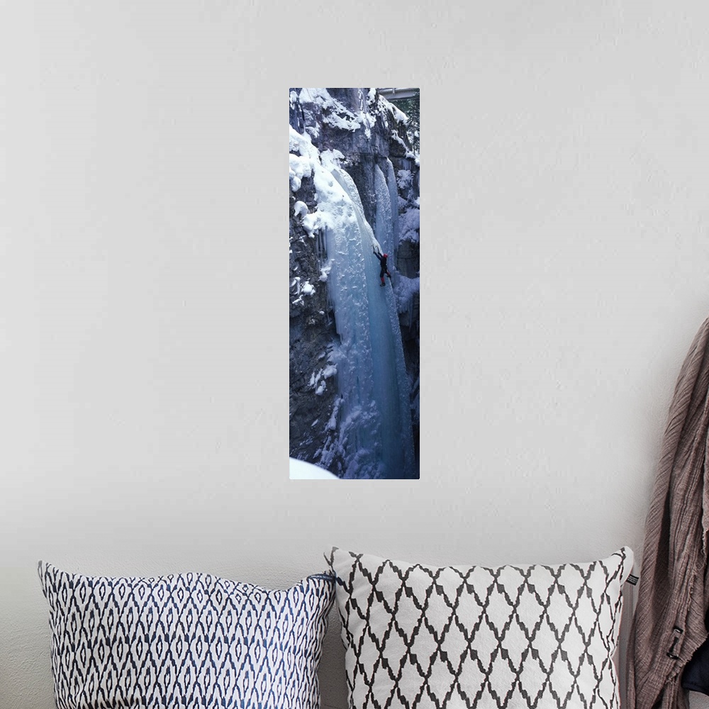 A bohemian room featuring Vertical panoramic photograph of climber on ice covered rock.