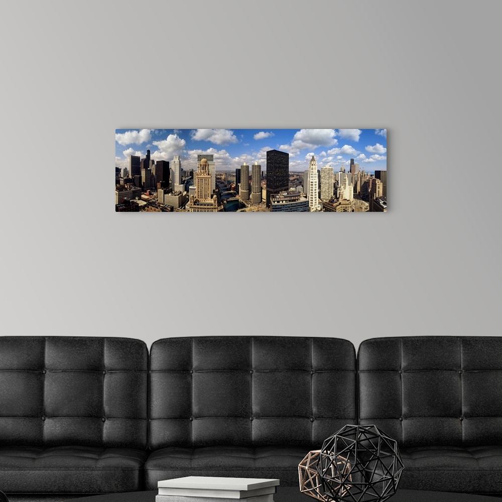 A modern room featuring Panoramic of tall buildings in Chicago with white puffy clouds in the sky.