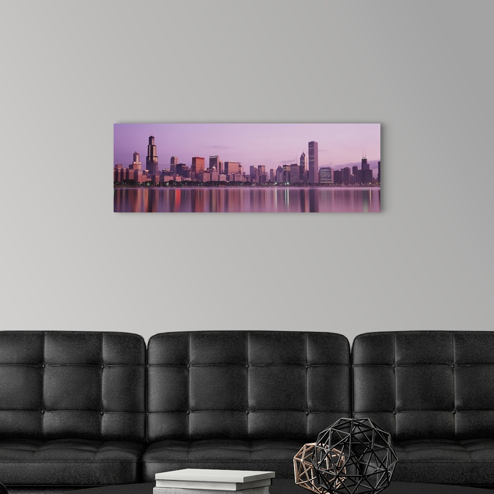 A modern room featuring Panoramic photograph of skyline and waterfront lit up at dusk.  The buildings are reflected in th...