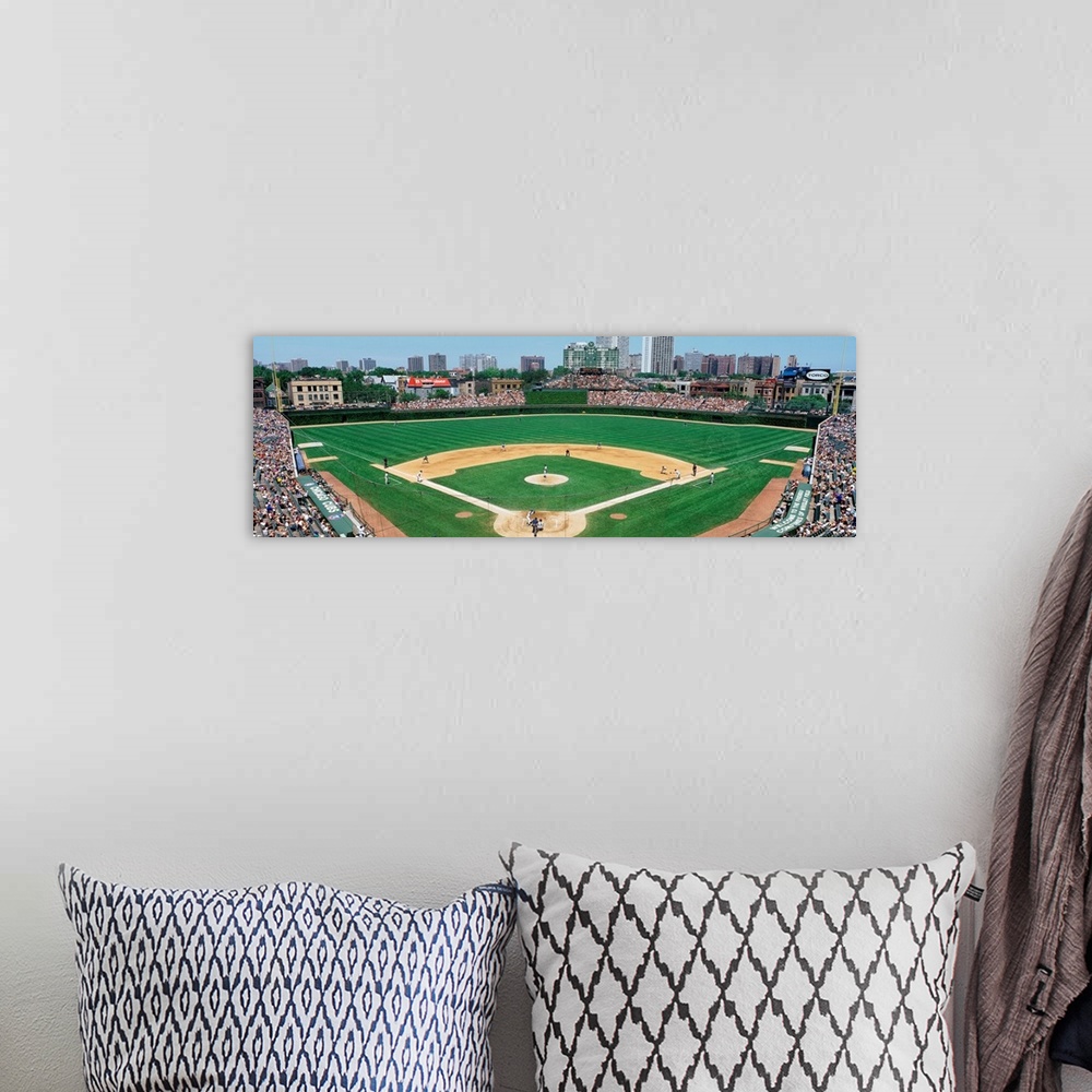 A bohemian room featuring Panoramic photograph of Wrigley Field with Chicago skyline in the distance.  Stadium is full of p...