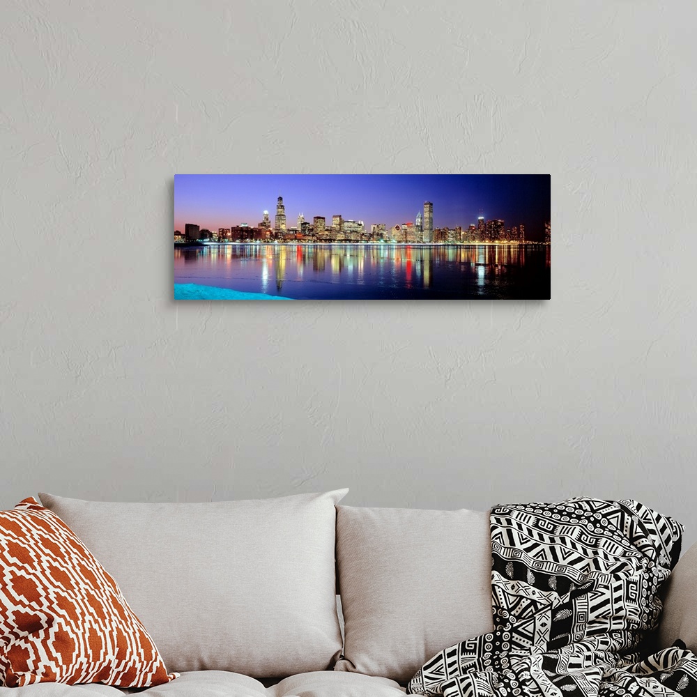 A bohemian room featuring Panoramic photographic canvas of a cityscape illuminated with colored lights reflected perfectly ...