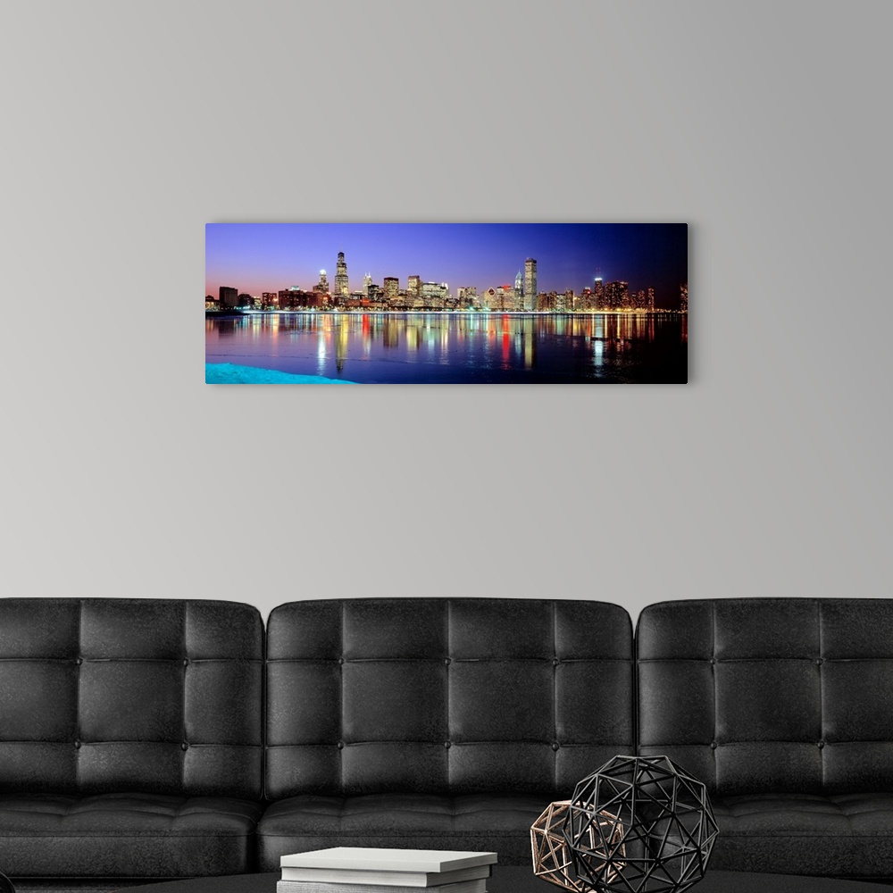 A modern room featuring Panoramic photographic canvas of a cityscape illuminated with colored lights reflected perfectly ...