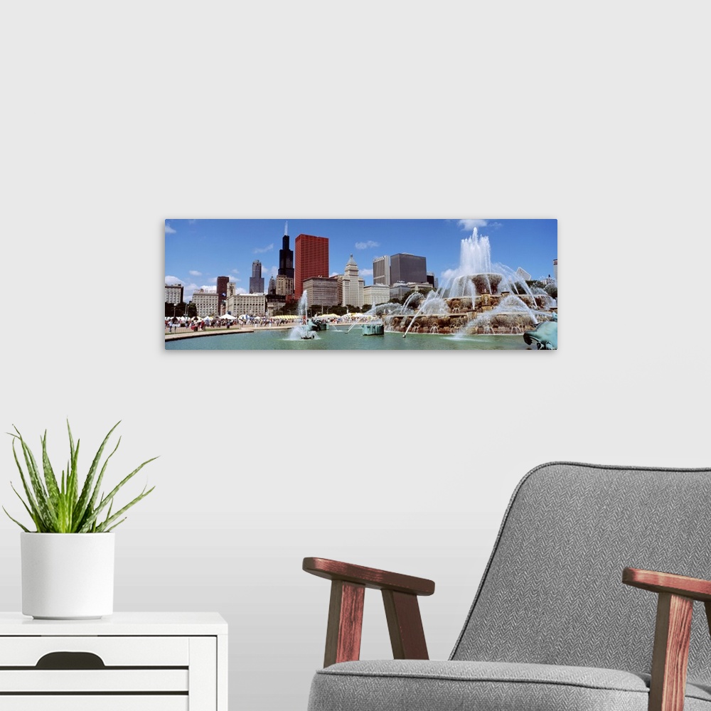 A modern room featuring Panoramic view of the Buckingham Fountain in the center of the busy city on a warm, sunny day.