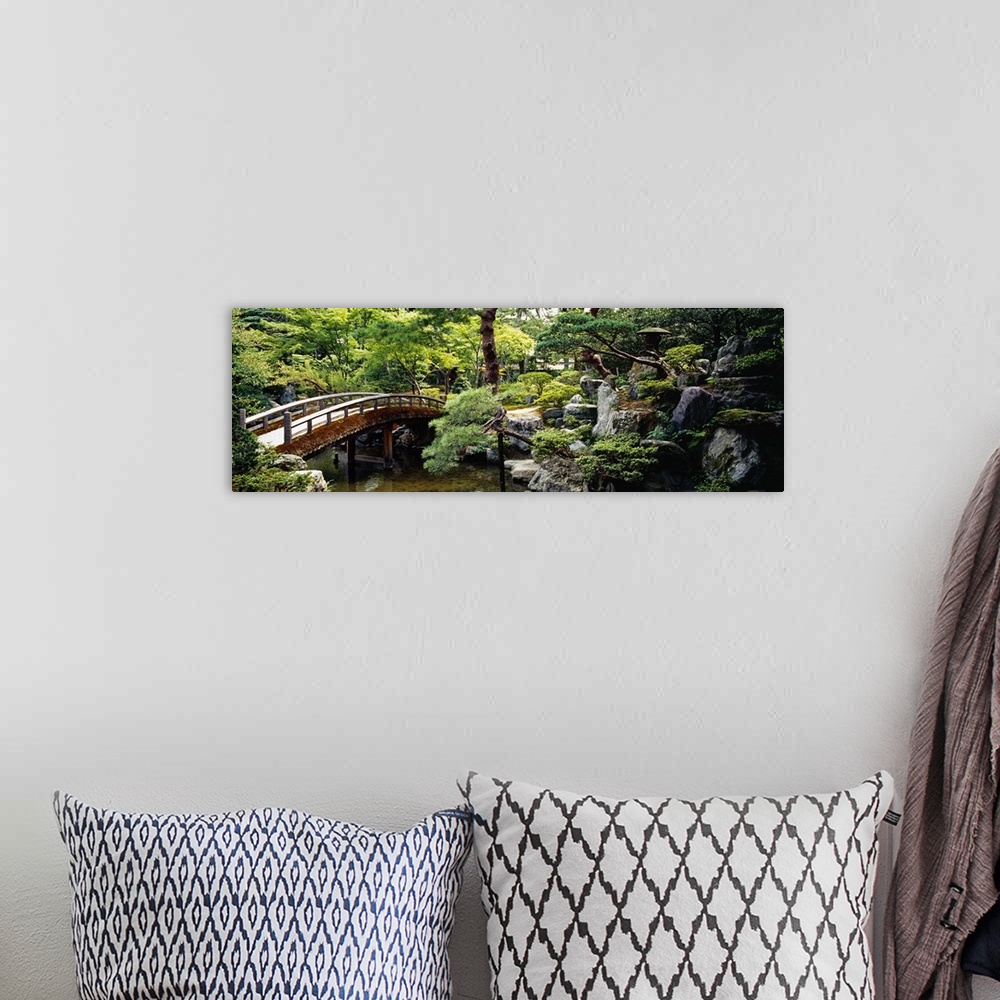 A bohemian room featuring Panoramic photo on canvas of a bridge leading over a river with a garden on the right.
