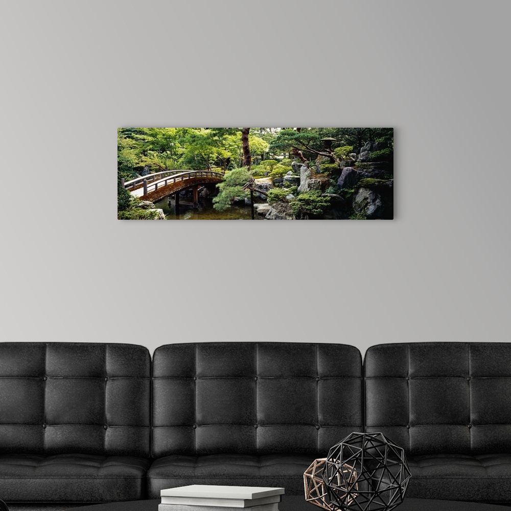 A modern room featuring Panoramic photo on canvas of a bridge leading over a river with a garden on the right.