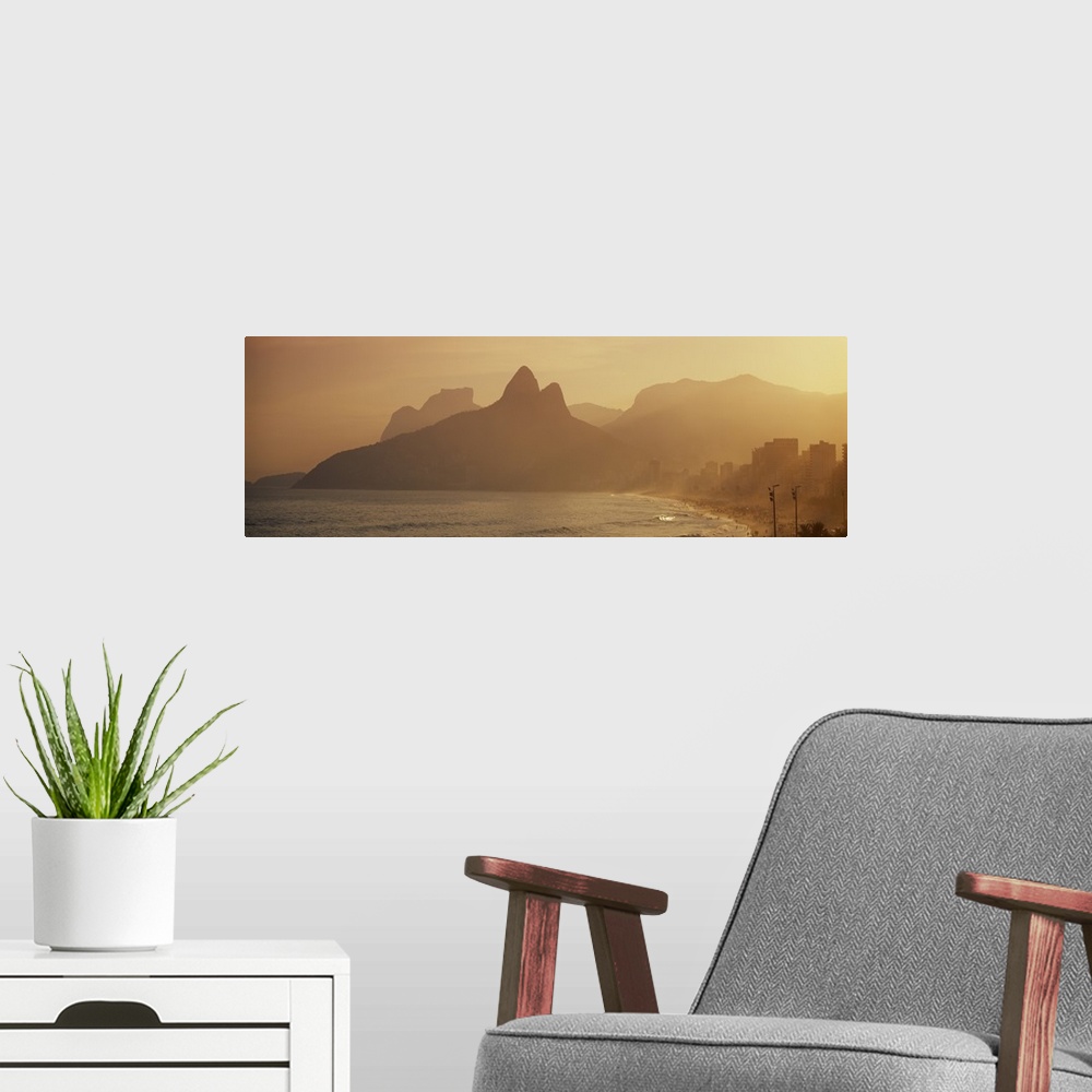 A modern room featuring Giant landscape photograph of silhouetted mountains near the coast of Ipanema Beach in Rio de Jan...