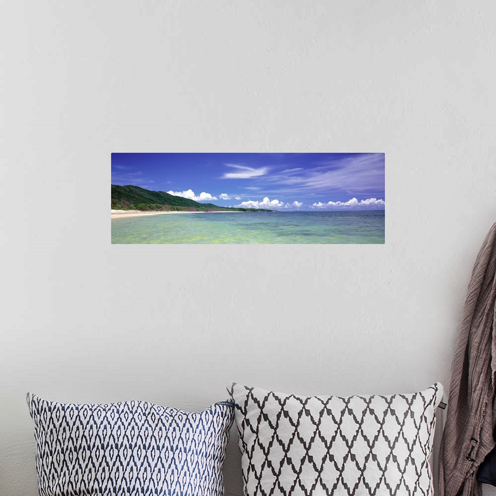 A bohemian room featuring Panoramic photograph of ocean with shoreline and grass covered mountains in the distance under a ...