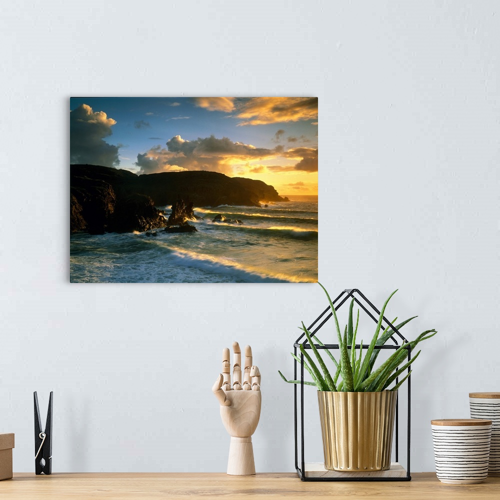 A bohemian room featuring Photograph of rock cliffs in ocean with waves rolling in under a cloudy sky at sunrise.