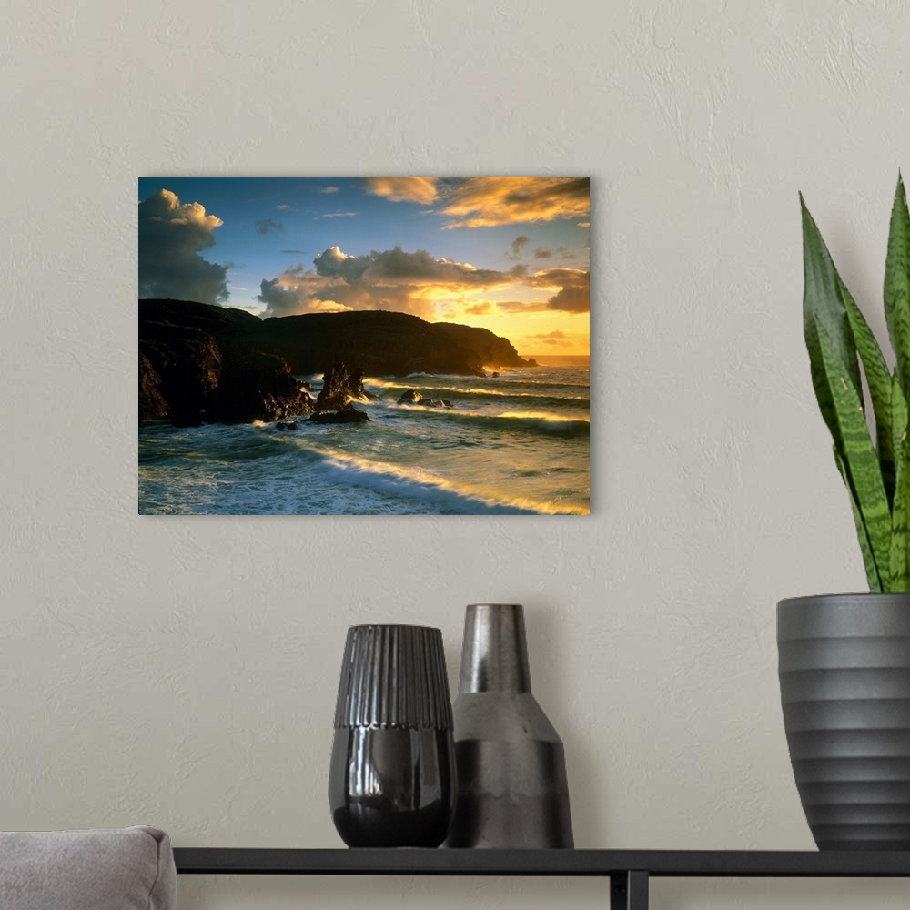 A modern room featuring Photograph of rock cliffs in ocean with waves rolling in under a cloudy sky at sunrise.