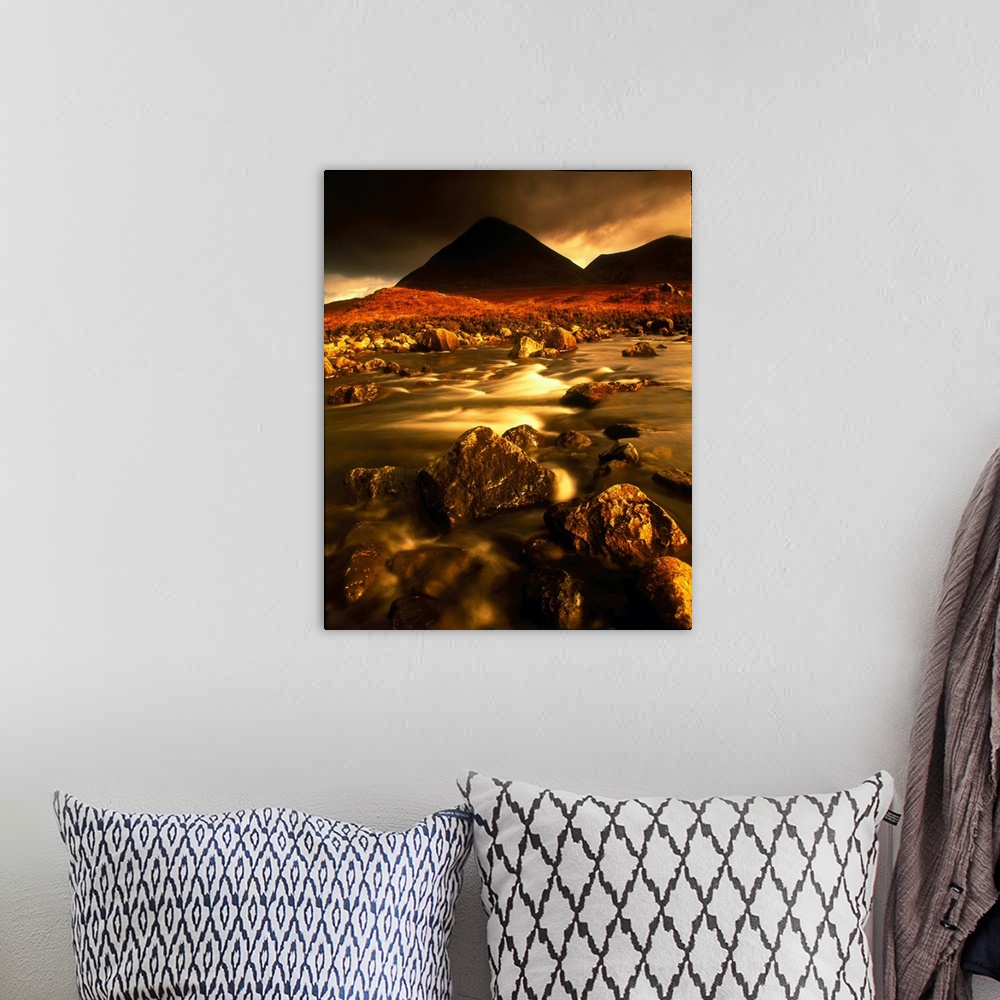 A bohemian room featuring Vertical panoramic photograph of rocky river bed with mountain silhouettes in the background unde...