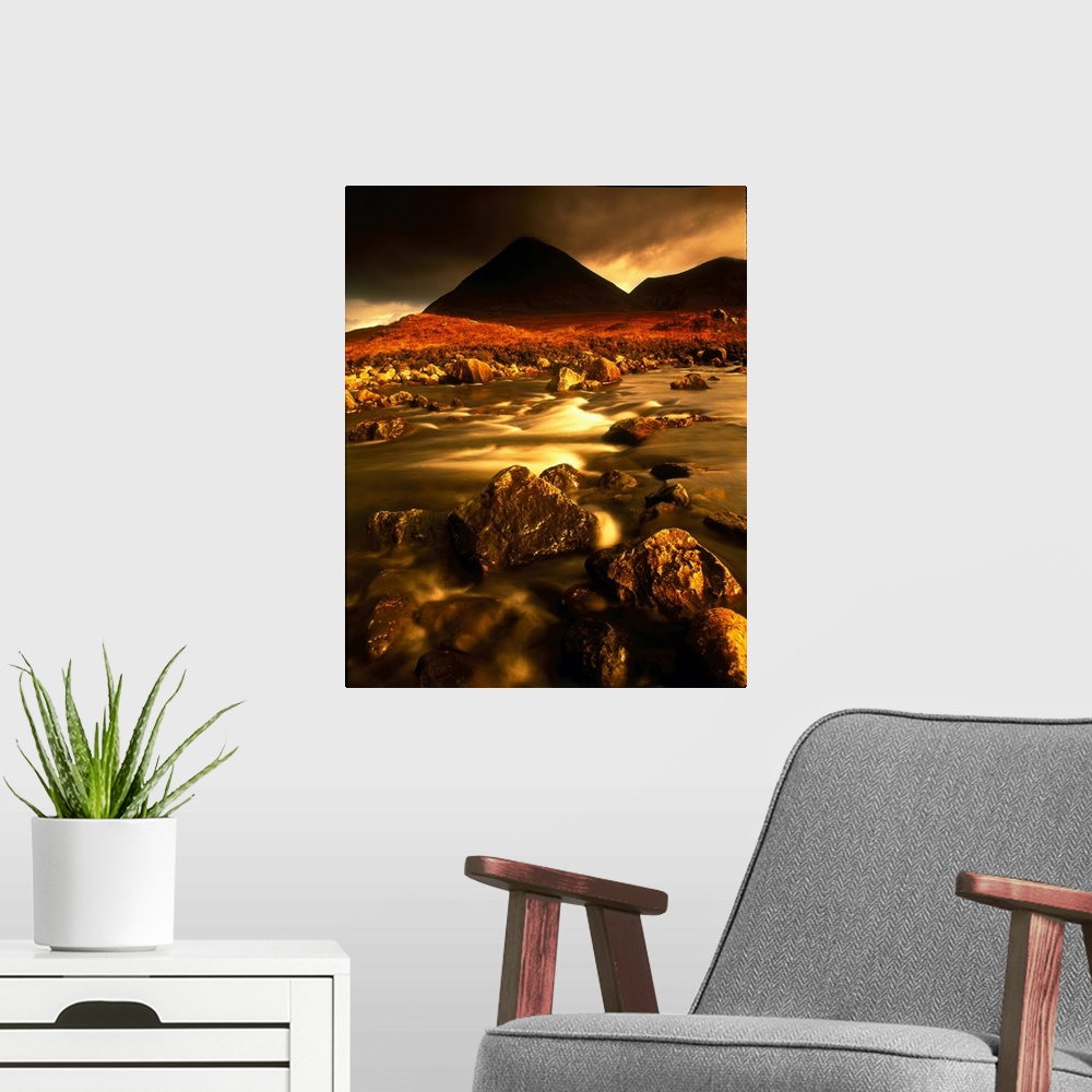 A modern room featuring Vertical panoramic photograph of rocky river bed with mountain silhouettes in the background unde...