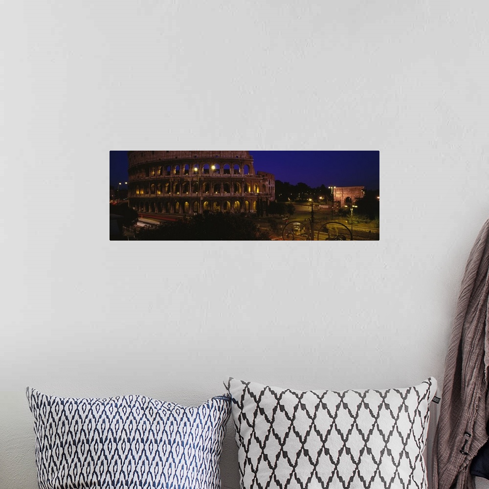 A bohemian room featuring Wide angle photograph of the Coliseum, lit up at night, in Rome, Italy.