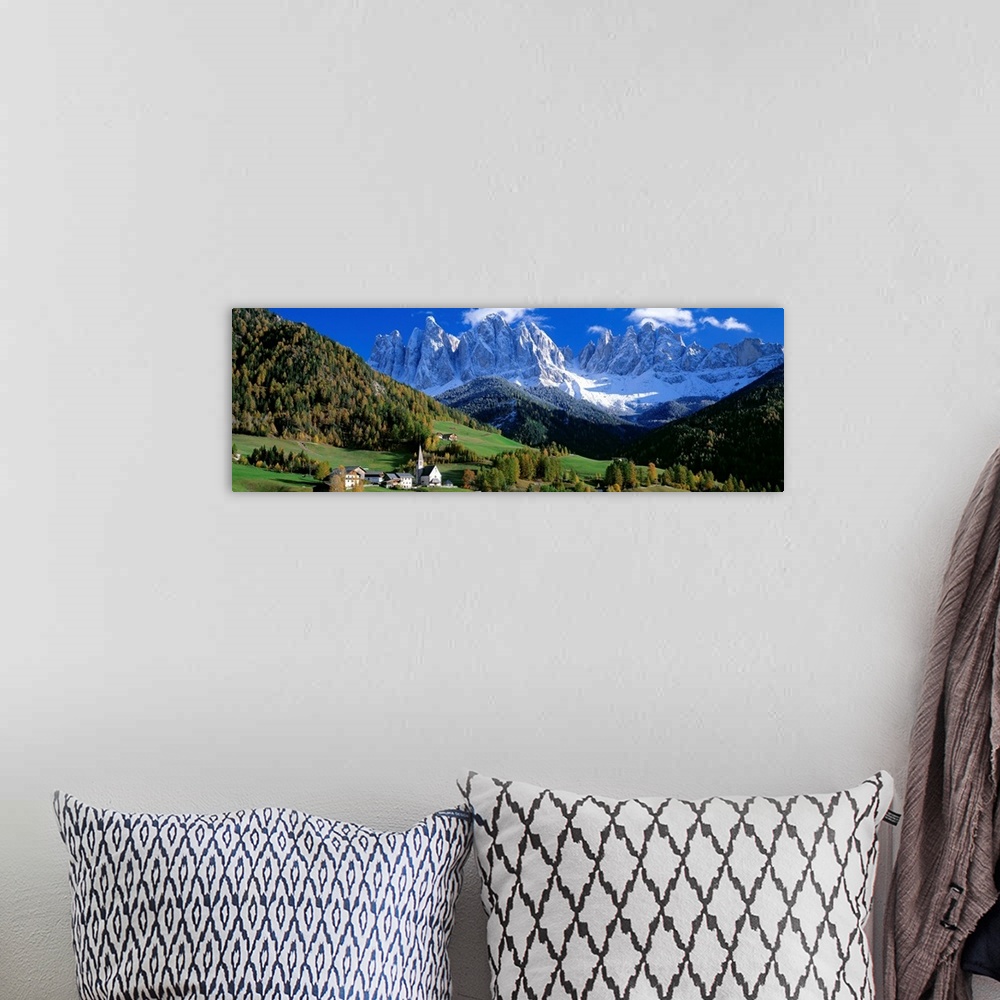 A bohemian room featuring The snow covered Alps tower over a quiet valley filled with conifer trees in this panoramic photo...