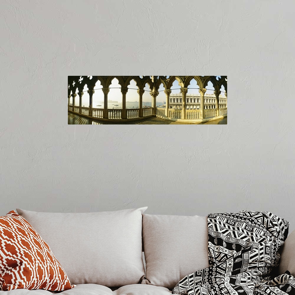 A bohemian room featuring Panoramic photo of decorative colomns in Italy over looking the ocean.
