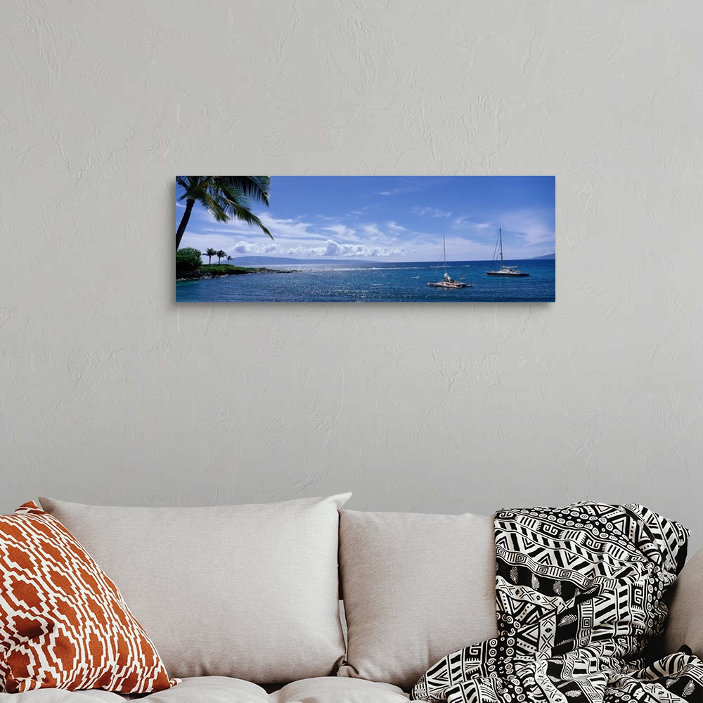 A bohemian room featuring Panoramic photograph taken of a bay in Hawaii with land and palm trees on the left side and two b...