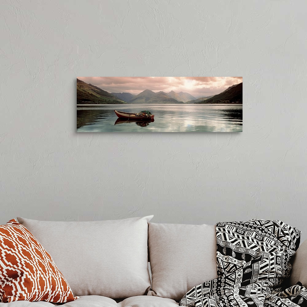 A bohemian room featuring Panoramic photograph shows a small fishing vessel sitting anchored within a calm body of water no...