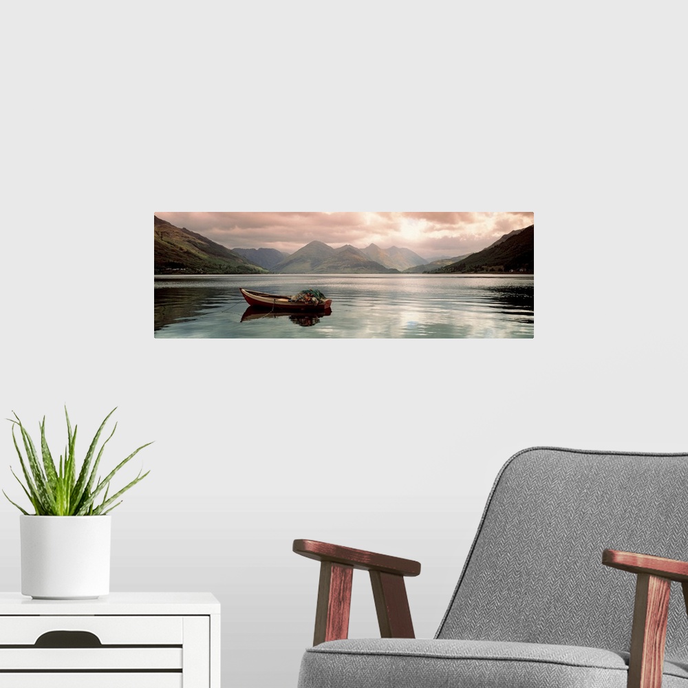 A modern room featuring Panoramic photograph shows a small fishing vessel sitting anchored within a calm body of water no...