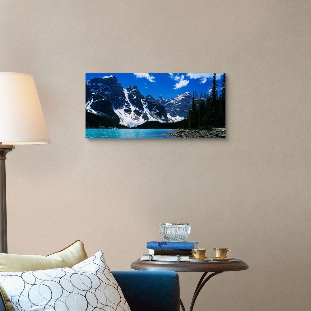 A traditional room featuring A landscape photograph of snow covered mountains surround a lake on this horizontal wall art.
