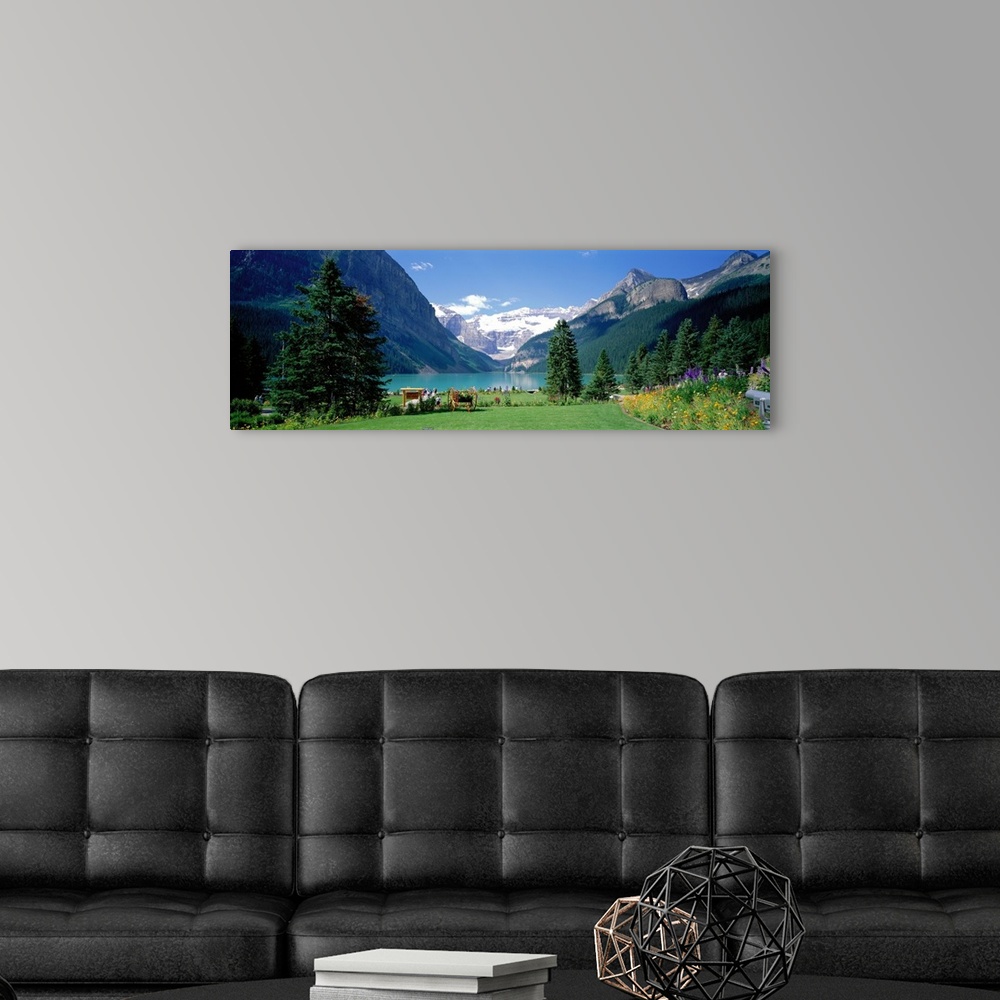A modern room featuring Panoramic wall docor of a smooth lakefront surrounded by rolling hills and snow capped mountains ...