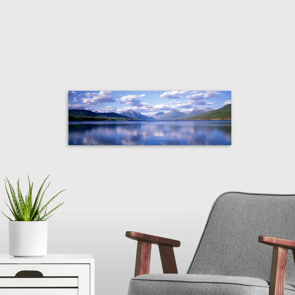 A modern room featuring Panoramic photograph Lake McDonald with small ripples in the water reflecting the mountains and t...