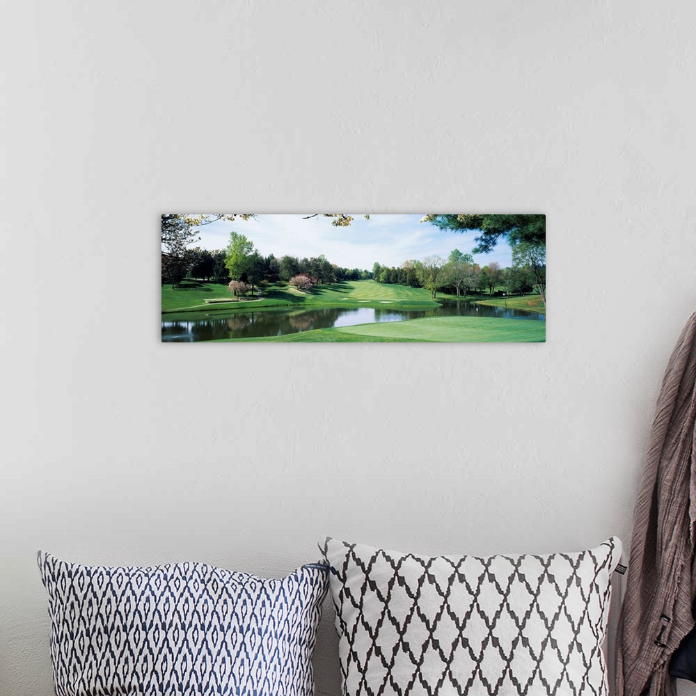 A bohemian room featuring Panoramic photograph of golf course featuring putting green, sand traps, and winding pond.  There...