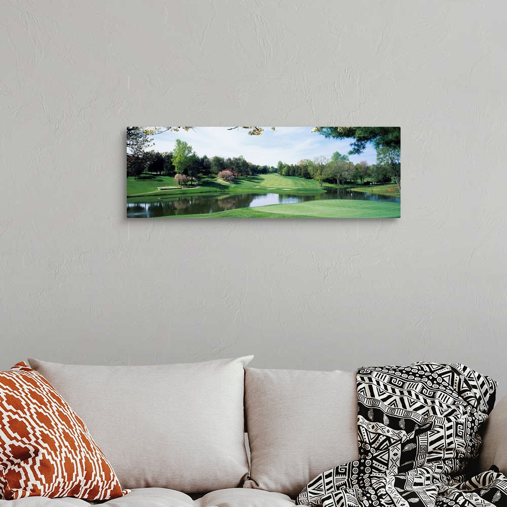 A bohemian room featuring Panoramic photograph of golf course featuring putting green, sand traps, and winding pond.  There...