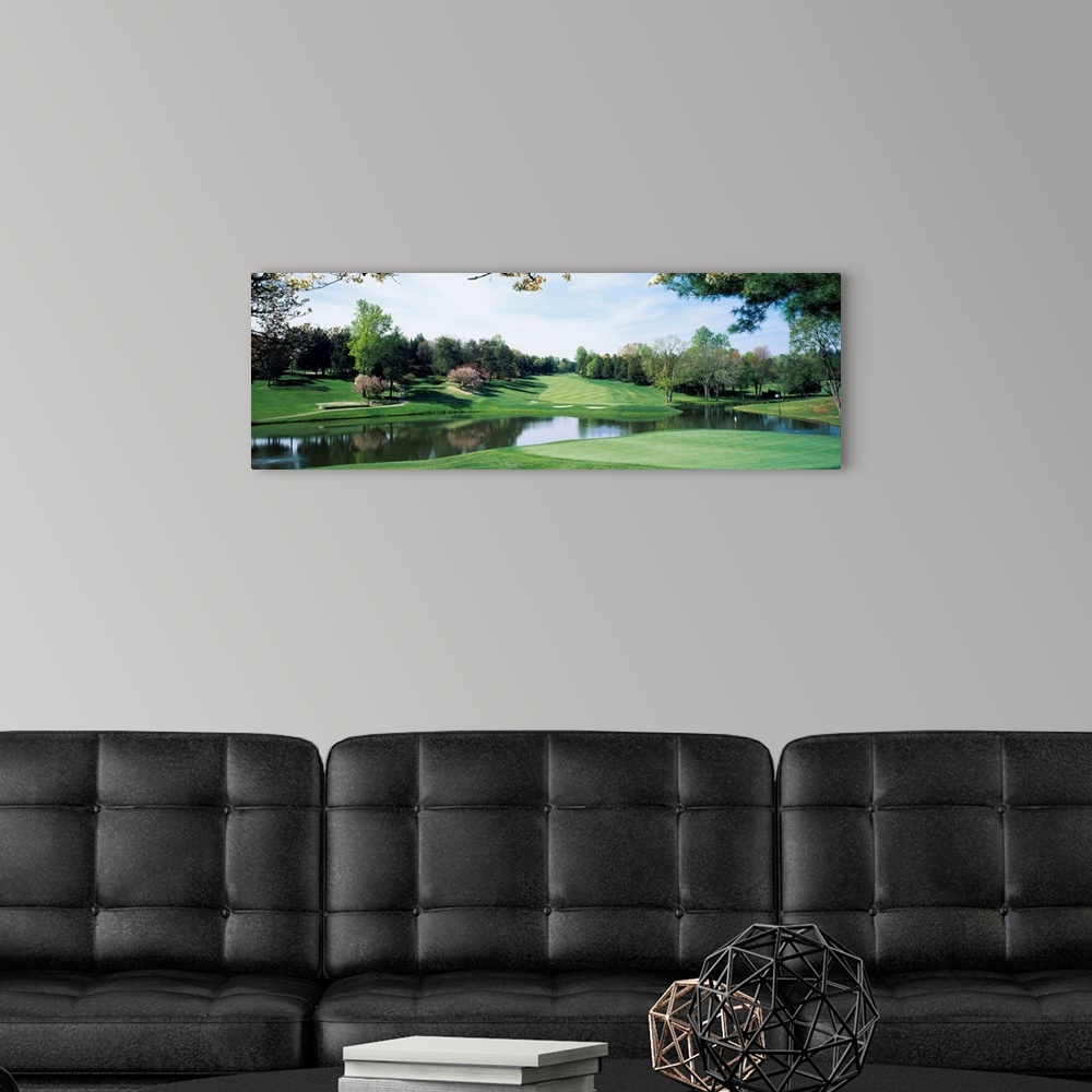 A modern room featuring Panoramic photograph of golf course featuring putting green, sand traps, and winding pond.  There...
