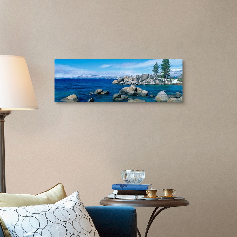 A traditional room featuring A panoramic photograph taken at eye level this home wall art shows the boulder covered shores of ...