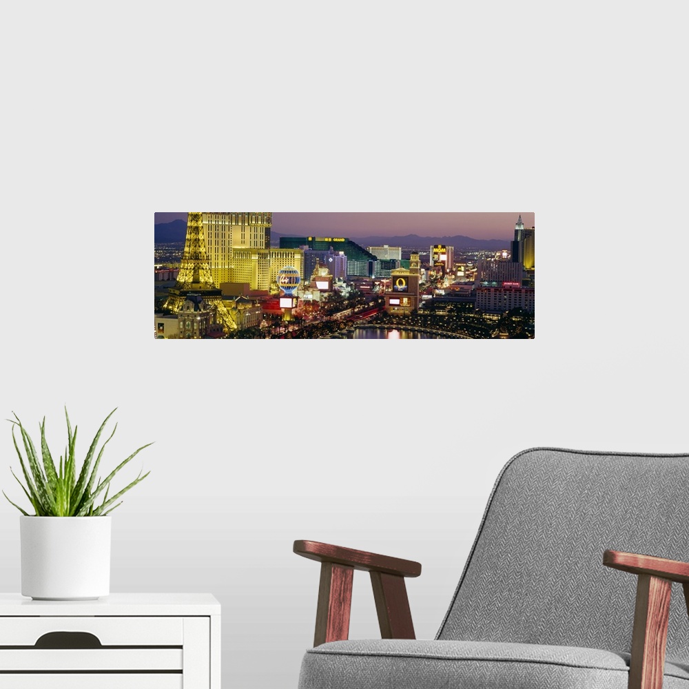 A modern room featuring Panoramic photograph taken of the Las Vegas skyline at night with the bright lights of the buildi...