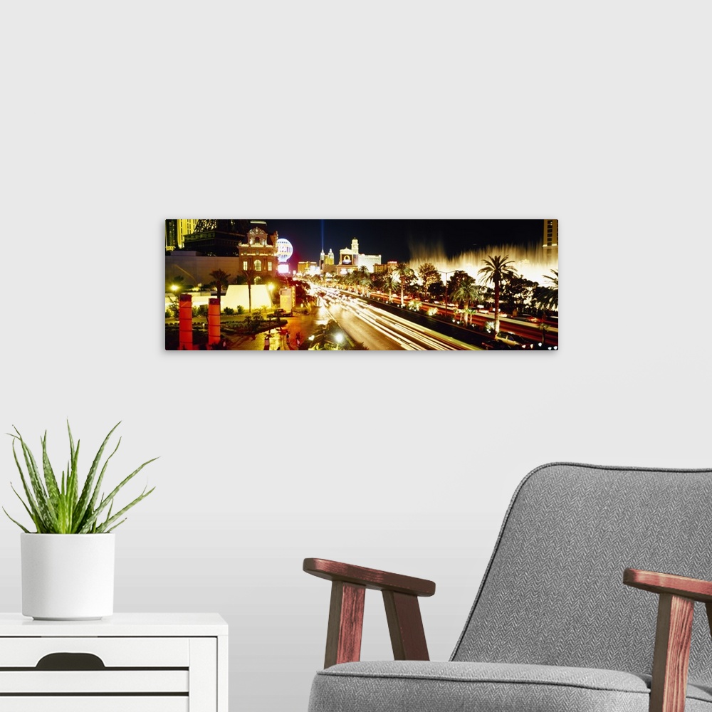 A modern room featuring Panoramic photograph of light trails from cars driving down the Las Vegas strip, bright lights sh...