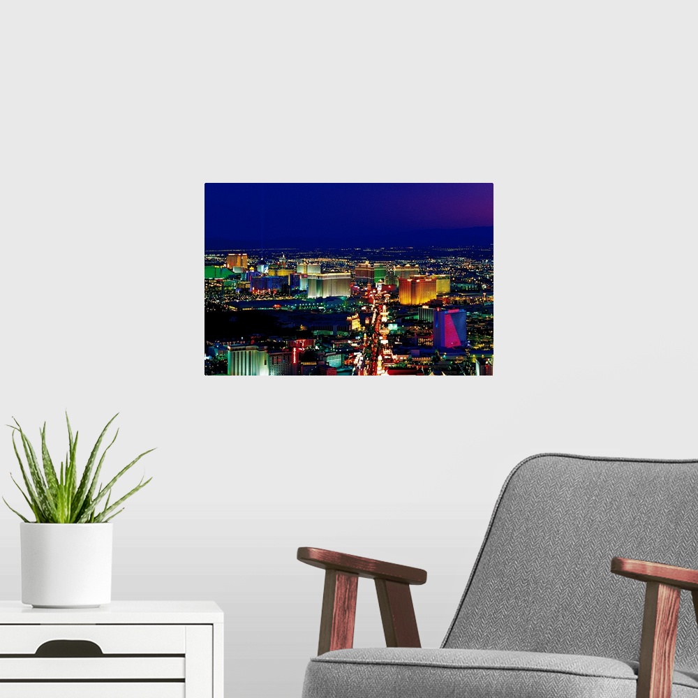 A modern room featuring View from above of the Las Vegas strip its neon lights glowing in the night sky in a horizontal p...