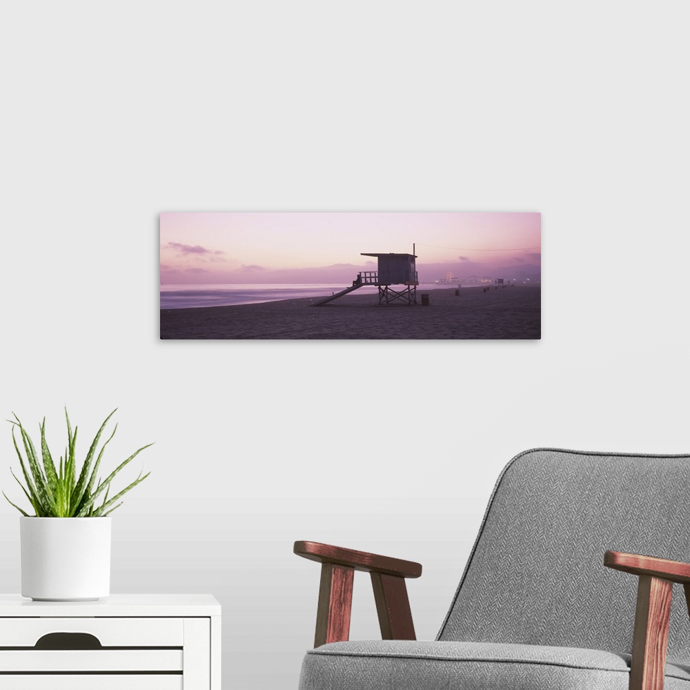 A modern room featuring Long horizontal photo print of a lifeguard station on the beach along the Pacific ocean with the ...