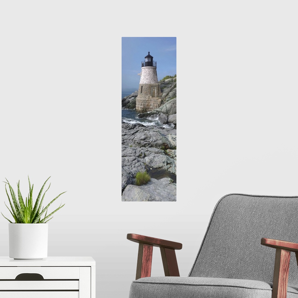 A modern room featuring This is a vertical photograph of light house on a rocky coast.