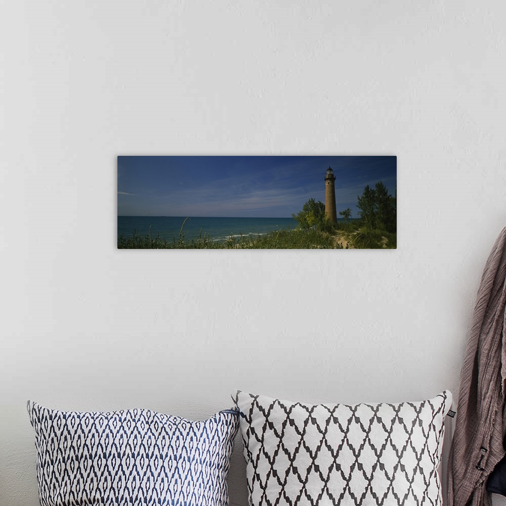 A bohemian room featuring Wide angle photograph of a lighthouse that is skewed to the right side of the picture and sits al...