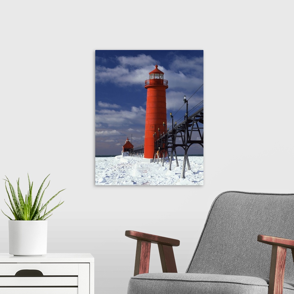 A modern room featuring A lighthouse in Michigan is photographed closely as snow covers the ground surrounding it.