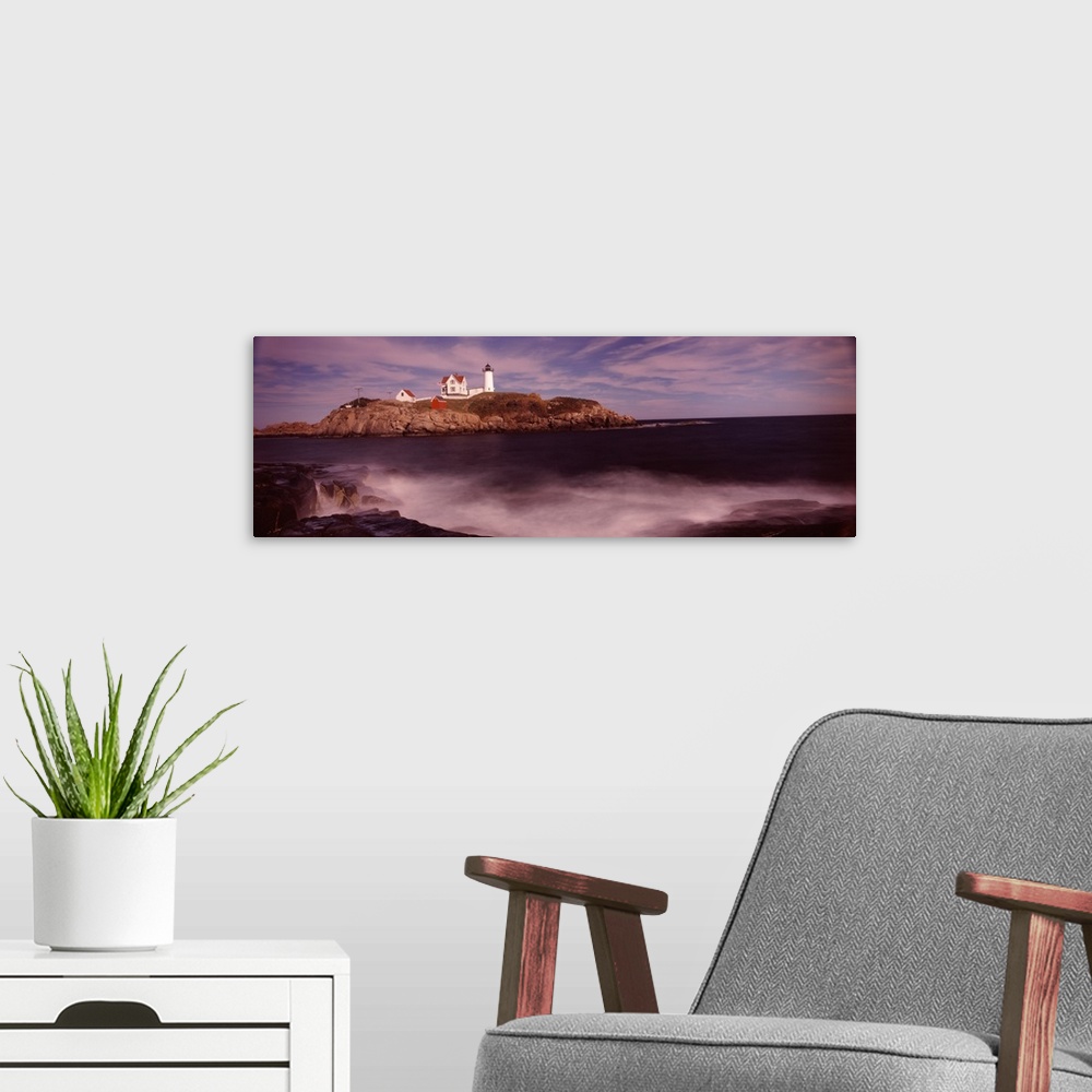A modern room featuring Panoramic photograph of Nubble Lighthouse on top of a rocky hillside, along the coast of York, Ma...