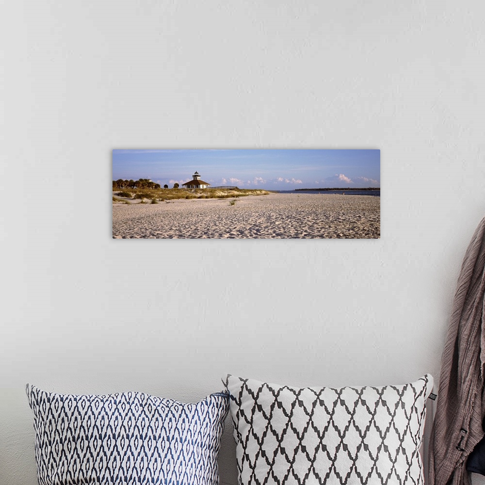 A bohemian room featuring An elongated view of a beach with a lighthouse off in the distance on top of the dunes.