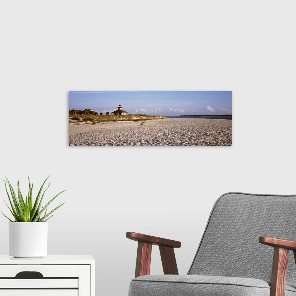 A modern room featuring An elongated view of a beach with a lighthouse off in the distance on top of the dunes.