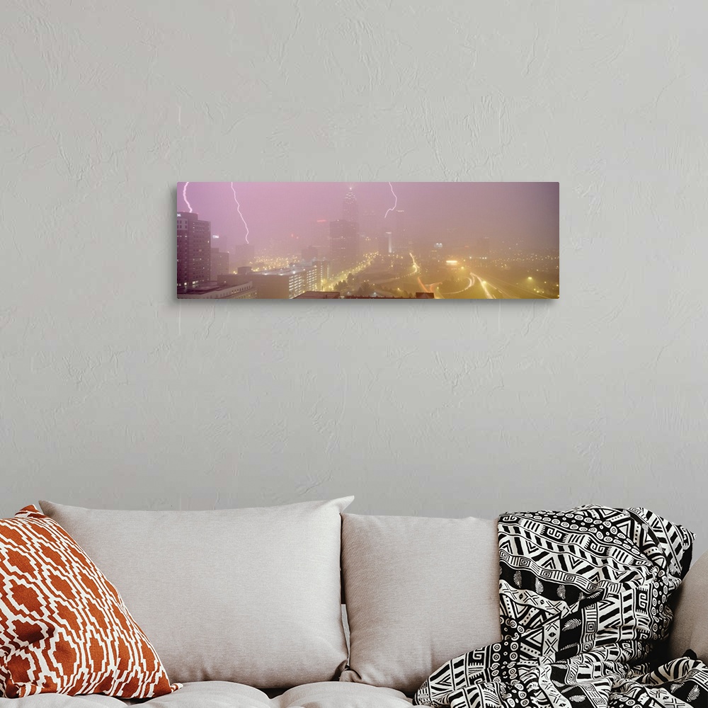 A bohemian room featuring Panoramic photograph of skyline with storm clouds and lightning bolts overhead.