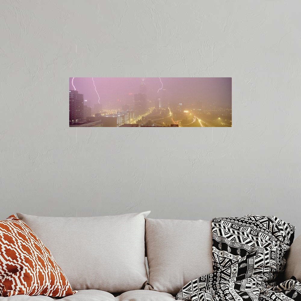 A bohemian room featuring Panoramic photograph of skyline with storm clouds and lightning bolts overhead.