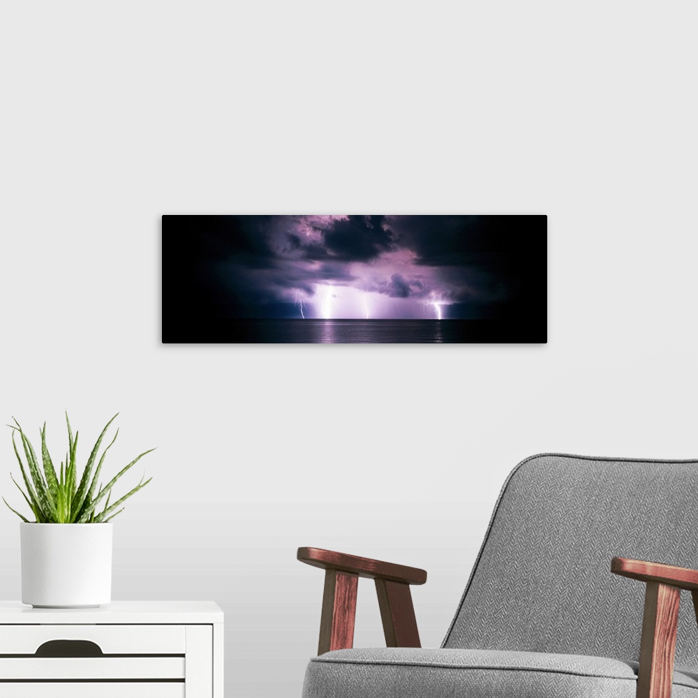 A modern room featuring Panoramic photograph of a dark, stormy sky, several bright lightening bolts striking the horizon ...