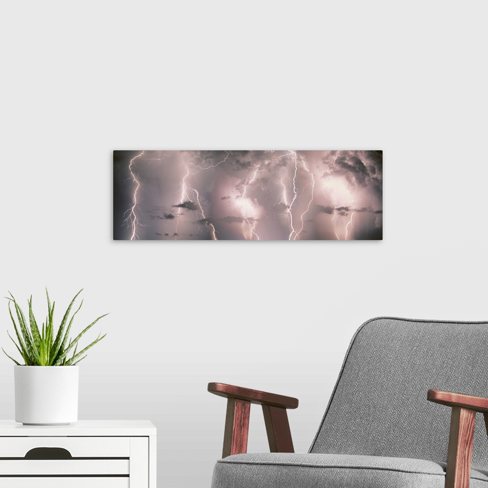 A modern room featuring Panoramic canvas of lightning strikes up close against a stormy lit up sky.