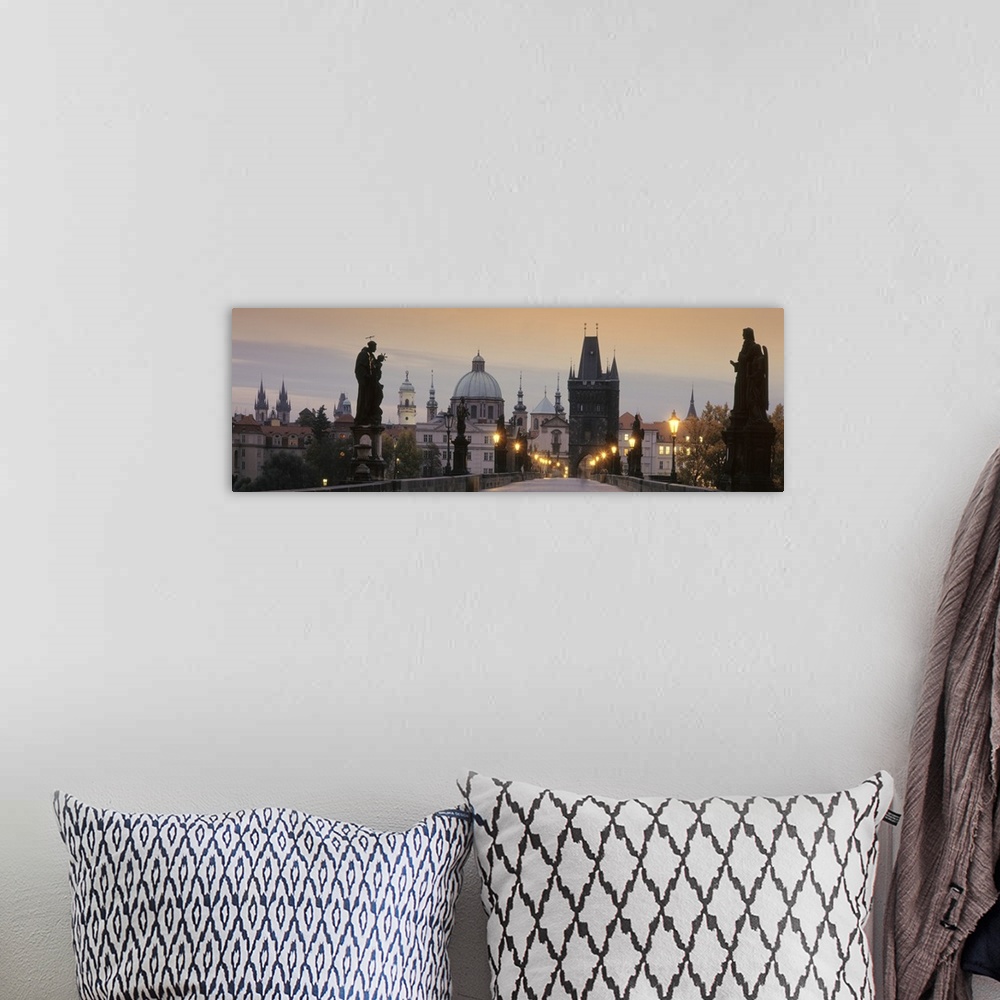 A bohemian room featuring Wide angle photograph of the Charles Bridge at sunset.  Statues on either side of the bridge, the...