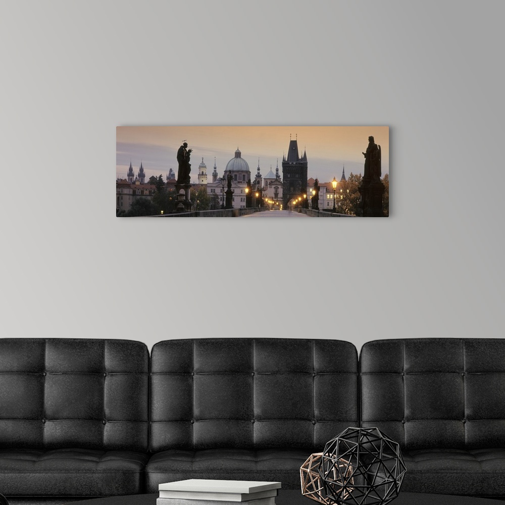 A modern room featuring Wide angle photograph of the Charles Bridge at sunset.  Statues on either side of the bridge, the...