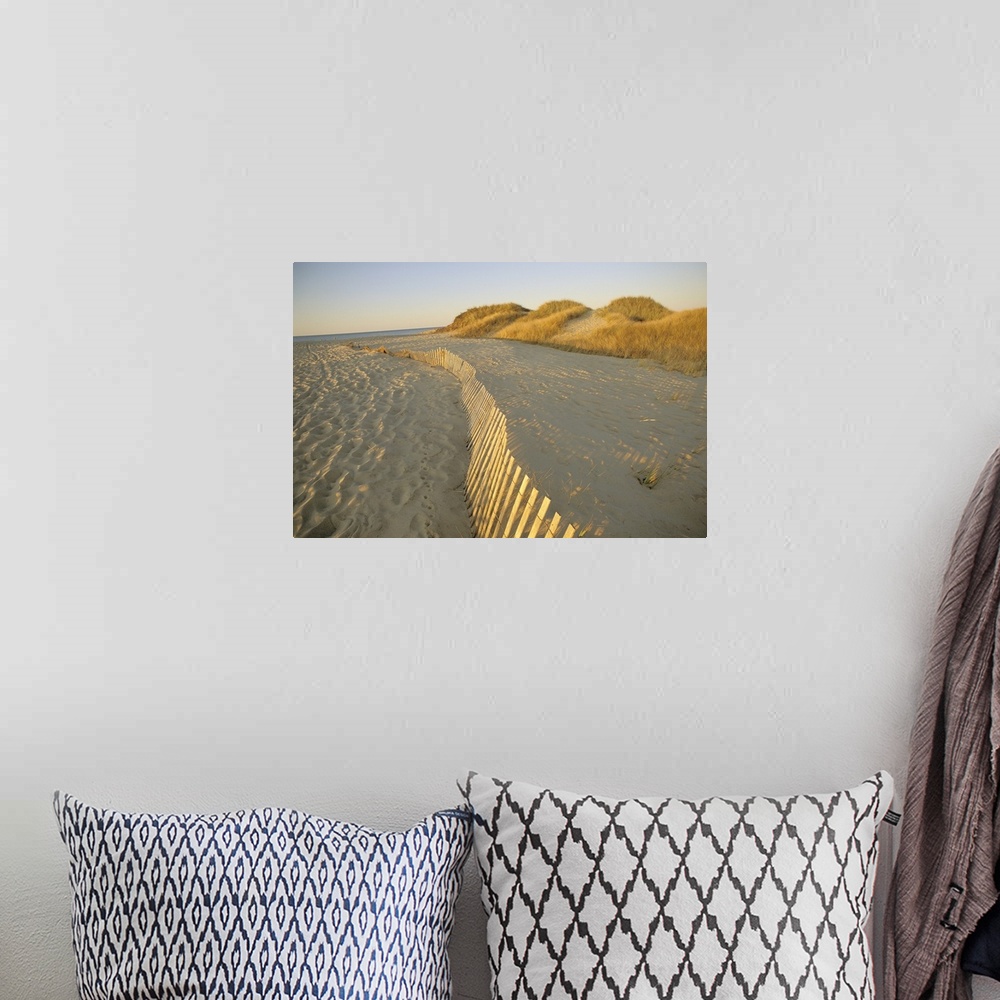 A bohemian room featuring Large photograph taken of a sandy beach that has a fence running through the middle of the pictur...