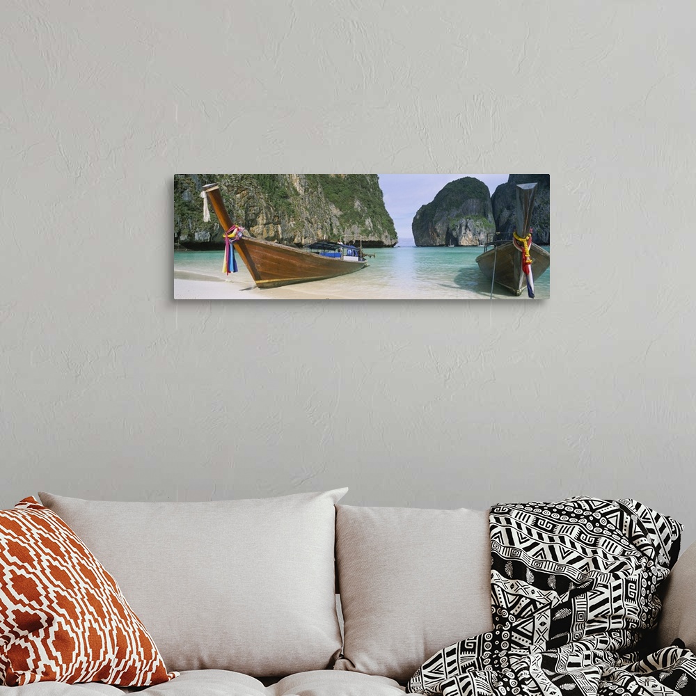 A bohemian room featuring Panoramic photograph of two big canoes docked in sand at the shoreline with huge rock formations ...