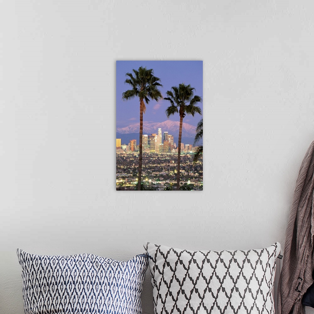A bohemian room featuring A vertical photograph of skyscrapers in the Los Angelesos skyline framed by two palm trees and mo...